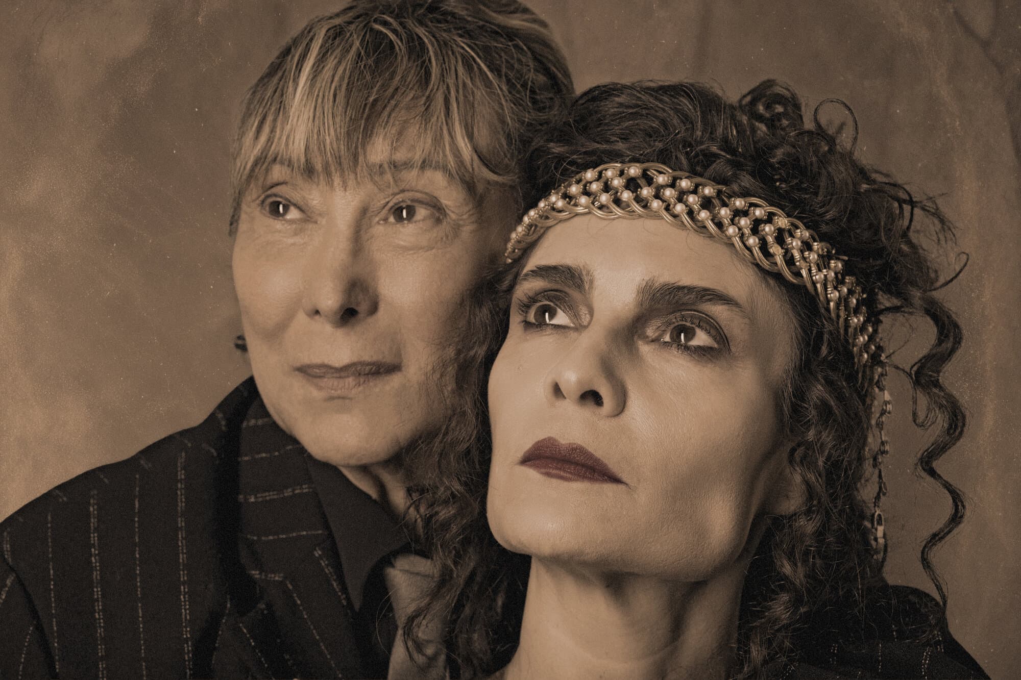 As atrizes que fazem Louise Abbéma e Sarah Bernhardt, rostos encostados, olhando na mesma direção
